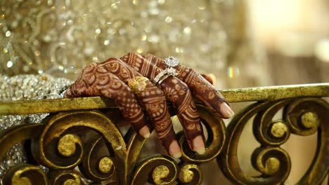 Close-Up-Of-Asian-Brides-Fingers-Covered-In-Beautiful-Mehndi-Design-Resting-Over-Railing