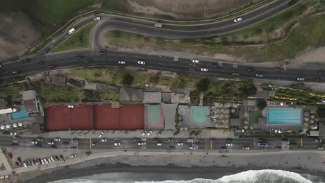 Pacific-vertical-aerial-of-traffic-below-Love-Park-cliffs-in-Lima-Peru