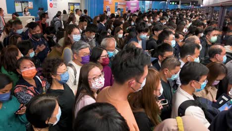 People-wearing-facial-masks-wait-in-line-during-rush-hour-for-a-subway-train-to-arrive-at-an-MTR-station-in-Hong-Kong