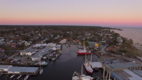 Aerial-Drone-Flyover-of-Oriental-NC-Harbor-and-town-docks-at-sunset-pull-back-shot-with-Diesel-Spill-facing-north