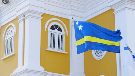 Bandera-Nacional-De-Curacao-Frente-A-Un-Hermoso-Edificio-Restaurado-Del-Patrimonio-Holandés-En-Willemstad,-Curacao