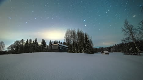 Wooden-Cabin-On-Snowy-Landscape-Under-Starry-Sky-At-Night