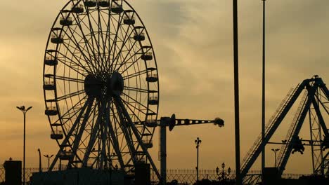 Amusement-Park-Ferris-Wheel-Silhouette-Against-Orange-Sunset-Sky