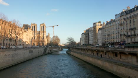 Schwenkansicht-Von-Der-Saint-Michel-Brücke-Mit-Der-Berühmten-Notre-Dame-Im-Hintergrund,-Während-Sie-Nach-Einem-Historischen-Brand-In-Paris,-Frankreich,-Wieder-Aufgebaut-Wird