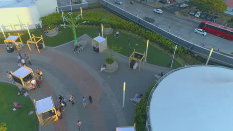 drone-video-in-shopping-mall-at-sunset,-outdoor,-sun-going-down,-people-walking,-little-shops