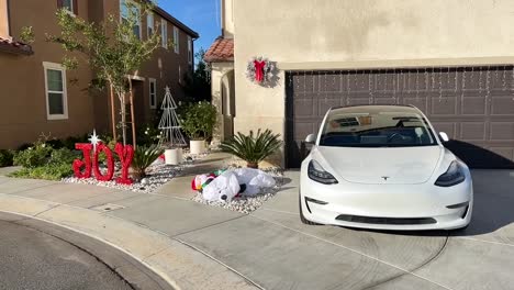Elektrisches-Tesla-auto-Geparkt-Außerhalb-Des-Sonnigen-Hauses,-Das-Festliche-Weihnachtsferien-Feiert