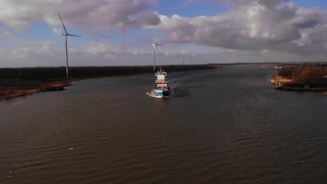 Aerial-Over-Oude-Maas-With-Greetje-Cargo-Seen-In-Distance-And-Wind-Turbines-Alongside-Riverbank