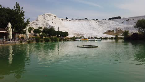 View-of-ducks-in-Pamukkale,-Denizli,-Turkey-with-the-white-hill-and-its-reflection-in-the-natural-pool-in-timelapse-at-daytime