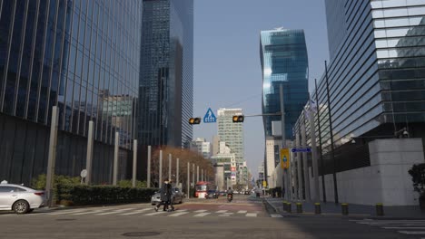Street-with-people-walking-and-cars-pass-by-between-Samsung-Headquarter-HQ-Glassy-Towers-in-Gangnam-district---static-daytime