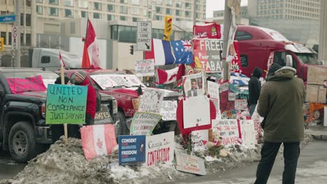 Trucker-Freedom-Convoy,-Mann-Steht-Vor-Plakaten,-Die-Die-Straße-In-Ottawa,-Kanada,-Blockieren