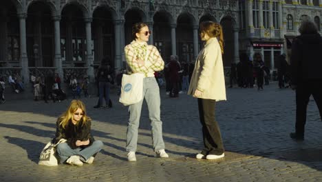 Chicas-Jóvenes-Hipster-Fumando-Y-Disfrutando-De-La-Vida-En-Grand-Place-En-Bruselas,-Bélgica