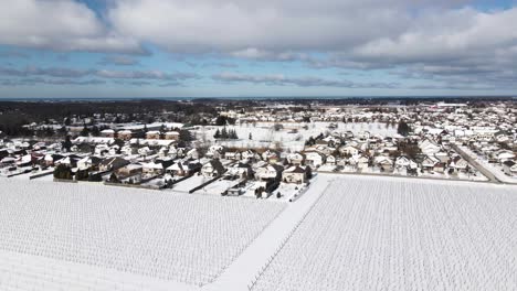 Aerial-of-farmland-and-neighboring-town-on-a-winter-blue-cloudy-day-Virgil,-Ontario