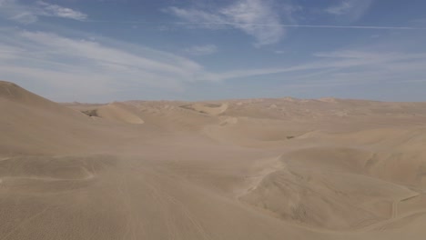 Aerial-rises-over-huge-wind-sculpted-sand-dunes-in-Peruvian-desert