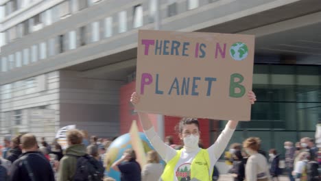 Global-Climate-Strikes-2021-At-Saint-Polten,-Austria---Female-Activist-In-Mask-With-A-Raised-Placard-That-Read-THERE-IS-NO-PLANET-B