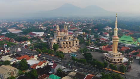 Al-Aqsa-Klaten-Mosque-with-Merapi-and-Merbabu-mounts-shrouded-in-fog-in-background,-Central-Java,-Indonesia