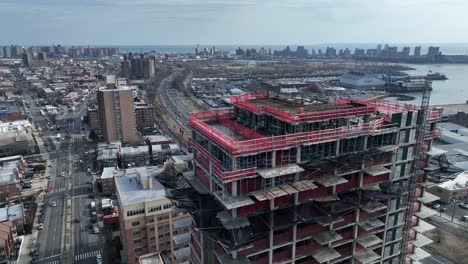 A-high-angle-view-above-Shore-Parkway-and-a-new-high-rise-construction-site-in-Brooklyn,-NY