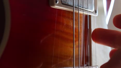 Fingers-picking-the-strings-of-a-Les-Paul-electric-guitar-in-cherry-sunburst