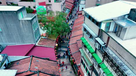 Ascending-aerial-shot-of-many-tourist-visiting-famous-historic-Shengkend-old-street-in-new-taipei-city