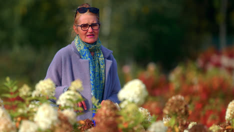 Mujer-Pensionista-Paseando-En-Un-Hermoso-Parque-Floral