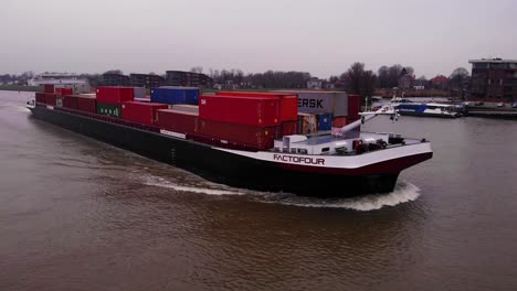 Luftaufnahme-Des-Schiffs-Factofour,-Das-Gestapelte-Container-Entlang-Des-Flusses-Noord-Transportiert