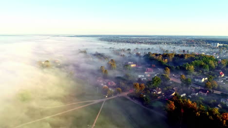 Drohne-Fliegt-Bei-Sonnenaufgang-über-Dem-Morgennebel-über-Einer-Kleinen-Ländlichen-Stadt
