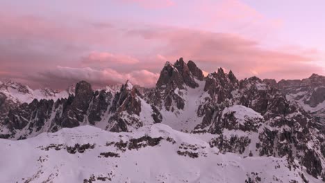 Aufsteigende-Drohnenaufnahme-Der-Italienischen-Dolomiten-Der-Candini-Gruppe-Im-Winter,-Schöner-Rosa-Sonnenuntergang