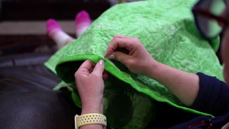 A-woman-hand-stitching-the-binding-of-a-quilt-she-made---close-up-slow-motion
