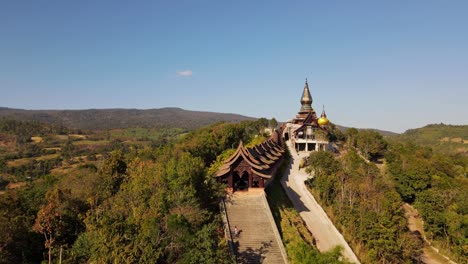 Aerial-footage-towards-the-temple-revealing-an-entrance-and-people-going-up-and-down-the-staircases,-Wat-Somdet-Phu-Ruea,-Ming-Mueang,-Loei-in-Thailand