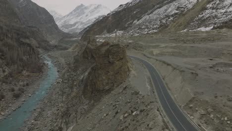 Amazing-scenic-windy-road-with-mountains-and-glacier-lake,-aerial-view