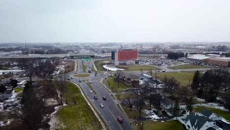 Drone-fly-above-traffic-road-in-the-city-center-with-modern-hospital-building