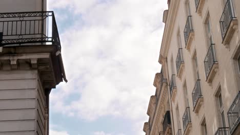 A-passenger-plane-coming-into-land,-passes-by-the-gap-between-two-old-buildings-in-Nantes,-France