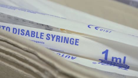 Disposable-plastic-syringe,-medical-preparations-in-background
