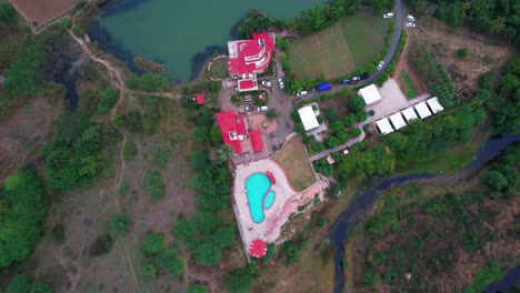 Aerial-view-of-a-close-up-of-a-complex-of-houses-with-a-relaxing-pool,-the-trees-look-small-due-to-the-high-height-of-the-shot-in-Vadodara,-India