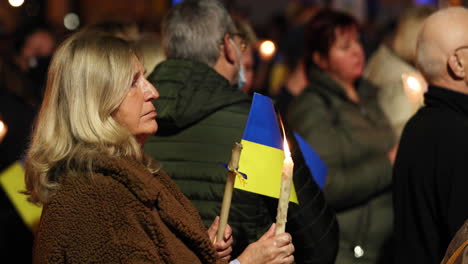 Portuguese-Woman-With-Ukrainian-Flaglet-And-Lit-Candle-During-Prayer-Vigil-For-Ukraine-In-Leiria,-Portugal