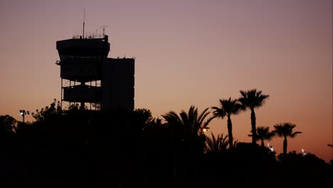 Aircraft-control-tower-at-a-tropical-airport-during-a-golden-sunset---time-lapse