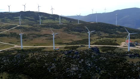 Luftaufnahme-Von-Sich-Schnell-Drehenden-Windparkturbinen-In-Hügeln-Von-Galizien-In-Spanien