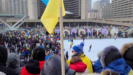 People-gathered-in-Nathan-Philips-Square-to-protest-Russia's-invasion-of-Ukraine,-Ukrainian-Flags