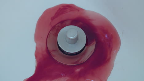 Close-up-of-blood-washing-down-a-shower-drain
