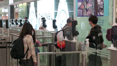 Passengers-go-through-the-security-check-at-Chek-Lap-Kok-International-Airport-departure-hall-in-Hong-Kong,-China