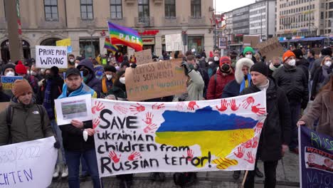 Save-Ukrainian-children-from-Russia-is-written-on-a-banner-at-peace-rally-in-Munich-after-Russia-invades-Ukraine