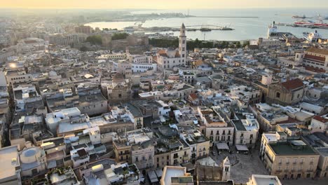 Aerial-drone-flying-over-buildings-and-a-cathedral-during-sunset-over-Bari-in-Italy
