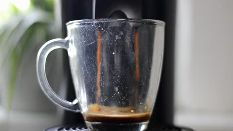 Coffee-maker-gets-switched-on,-then-starts-pouring-coffee-in-two-streams-into-a-glass-cup