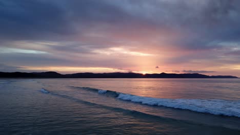 Fliegen-Sie-Bei-Sonnenuntergang-über-Meereswellen-In-Der-Spirits-Bay-In-Der-Nähe-Von-Cape-Reinga-Auf-Der-Halbinsel-Aupouri,-Nordinsel,-Neuseeland