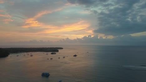 Wonderful-aerial-view-flight-panorama-curve-flight-drone-footage-after-a-paradise-dream-sunset-with-colourful-clouds-at-Mushroom-Bay-Lembongan
