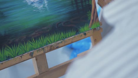 Painter-brushing-grass-detail-with-fine-brush-on-artwork