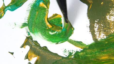 Close-up,-brush-painting-artwork-with-green-and-yellow-paint-on-white-background