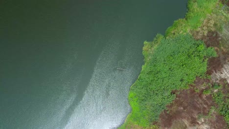 Victoria-Island-Lagos,-Nigeria---15-March-2022:-Drone-view-of-a-fisherman-on-a-fishing-boat-in-Kuramo-waters