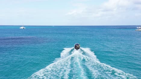 Tracking-drone-shot-behind-local-Caribbean-boat-taking-tourists-out-for-diving