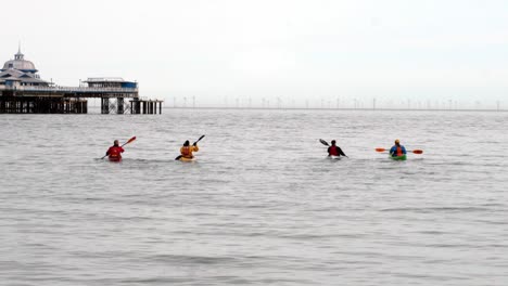 Group-of-friends-early-morning-Kayaking-voyage-navigate-towards-Llandudno-pier