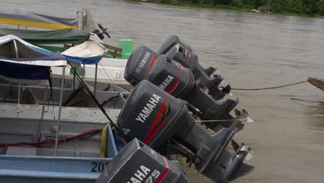 Flussboote-Mit-Yamaha-Motoren,-Die-Am-Ufer-Eines-Großen-Flusses-Angedockt-Sind